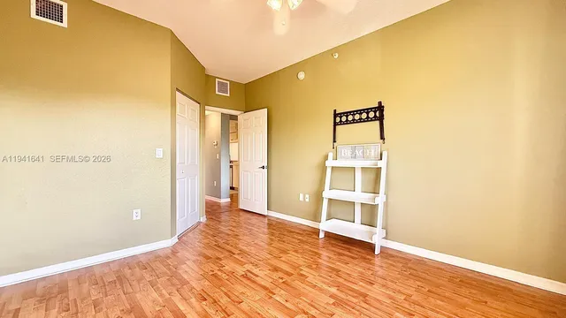 a view of a big room with wooden floor and windows