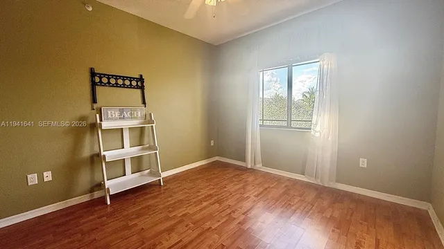 an empty room with wooden floor and window