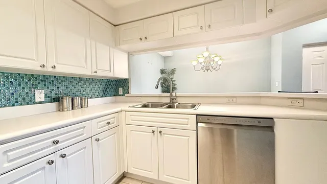 a kitchen with white cabinets and sink