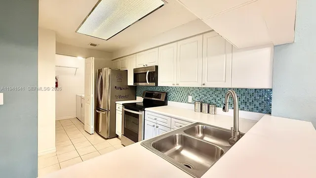 a kitchen with stainless steel appliances kitchen island granite countertop a refrigerator and a stove top oven