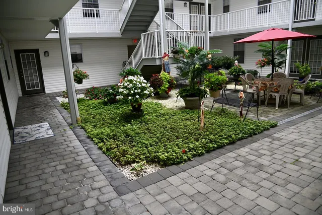 a view of a patio with chairs and a table under an umbrella