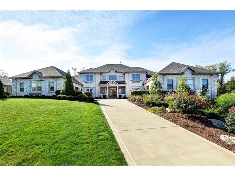 Exterior Front. Driveway leads to the leaded double glass front door with double garage on either side of the home.
