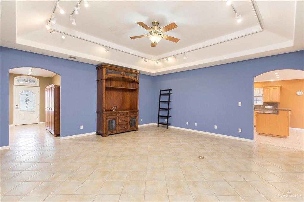 100 West Moore Road, Unit UT1 Pharr, TX 78577 - Photo 2 of 21 Living room featuring arched walkways, track lighting, a tray ceilings, a ceiling fan, and light tile patterned floors