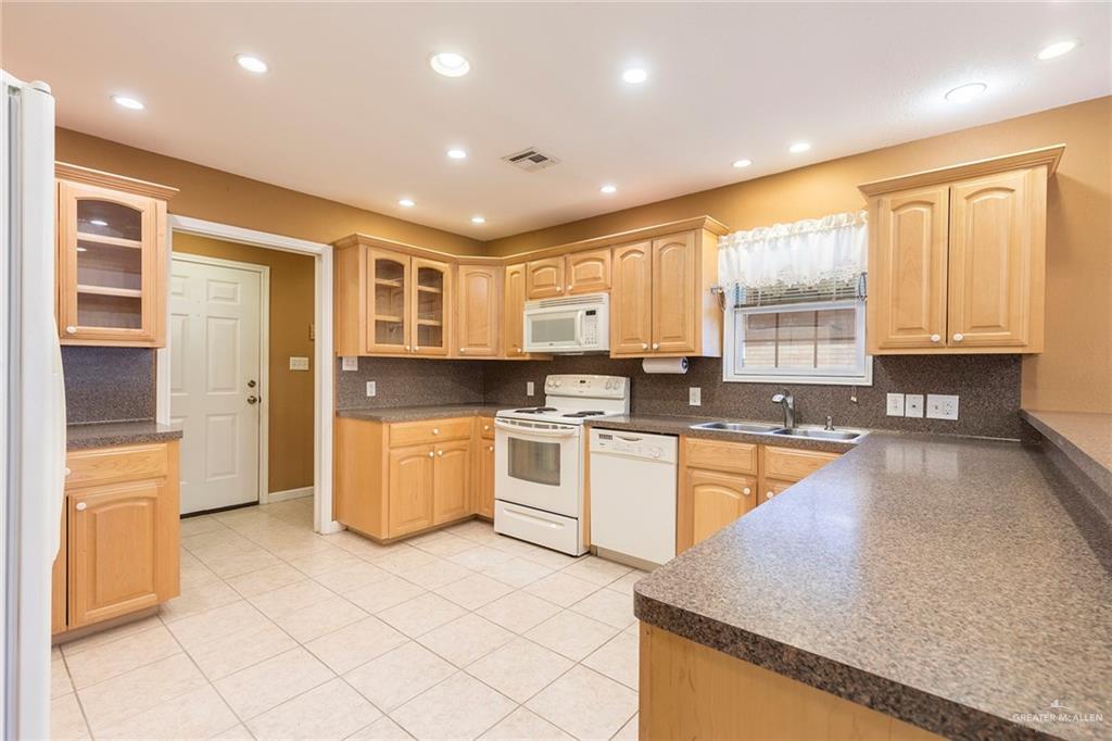 100 West Moore Road, Unit UT1 Pharr, TX 78577 - Photo 3 of 21 Kitchen with laminate countertops, white appliances, light wood finish custom cabinetry. View of laundry room
