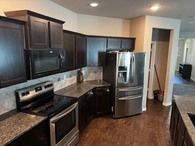 a kitchen with stainless steel appliances and wooden cabinets
