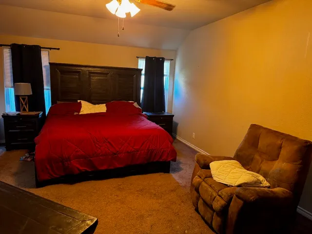 a bed sitting in a bedroom next to a lamp