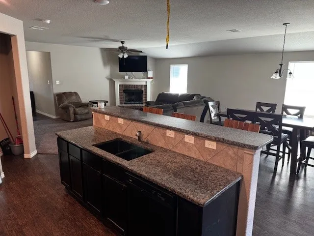 a kitchen with stainless steel appliances granite countertop a sink a stove and a wooden floors