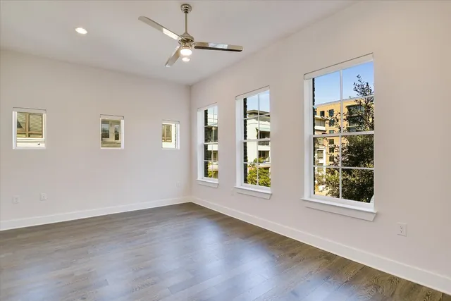 a view of an empty room with a window and wooden floor