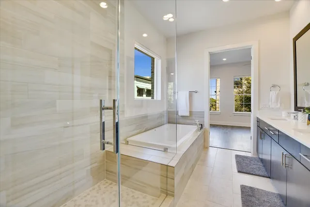 a spacious bathroom with a granite countertop tub sink and mirror