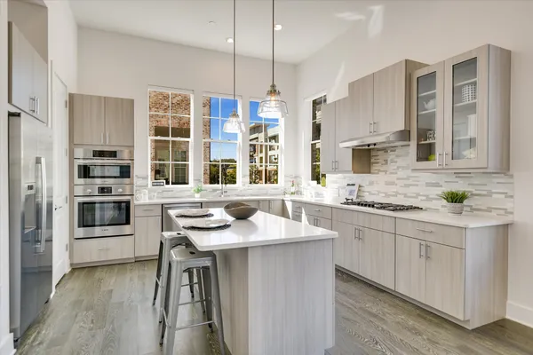 a kitchen with stainless steel appliances kitchen island granite countertop a sink stove and refrigerator