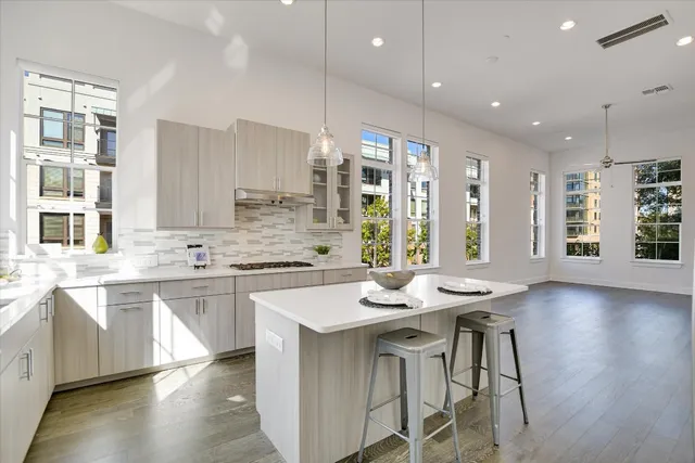 a kitchen with stainless steel appliances granite countertop wooden floor window and cabinets