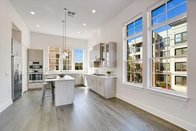 a large kitchen with a large window and stainless steel appliances