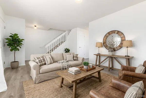 a living room with furniture a chandelier and a potted plant