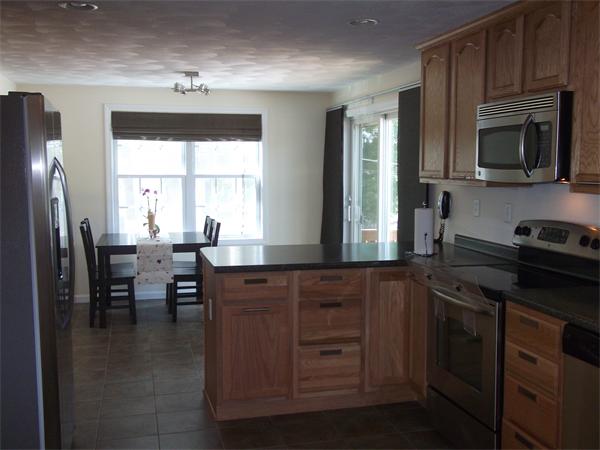 19 Ingersoll Road Billerica, MA 01821 - Photo 7 of 23 a kitchen with a table chairs microwave and cabinets