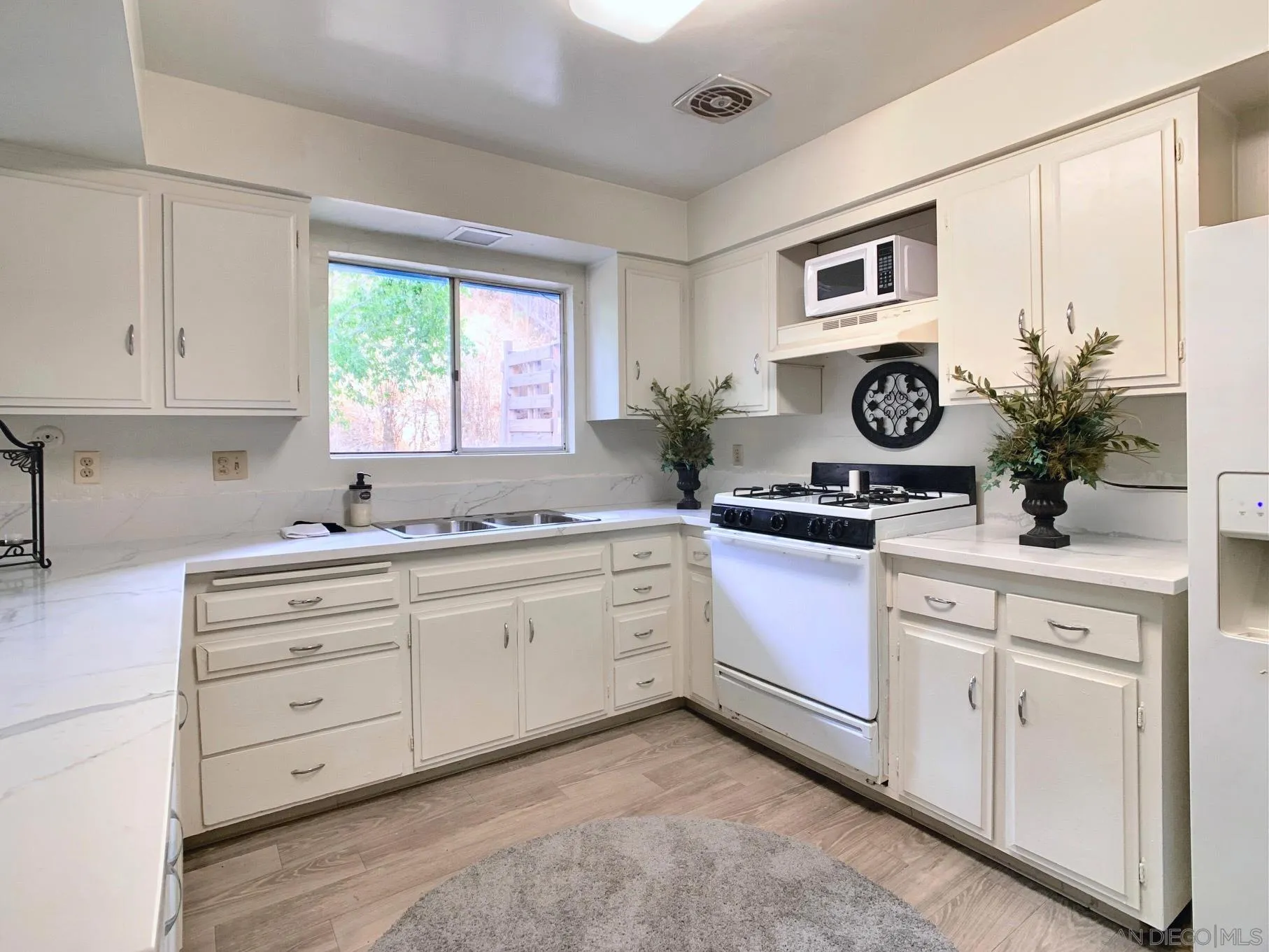 10111 Norte Mesa Drive Spring Valley, CA 91977 - Photo 7 of 29 a kitchen with granite countertop white cabinets and white stainless steel appliances