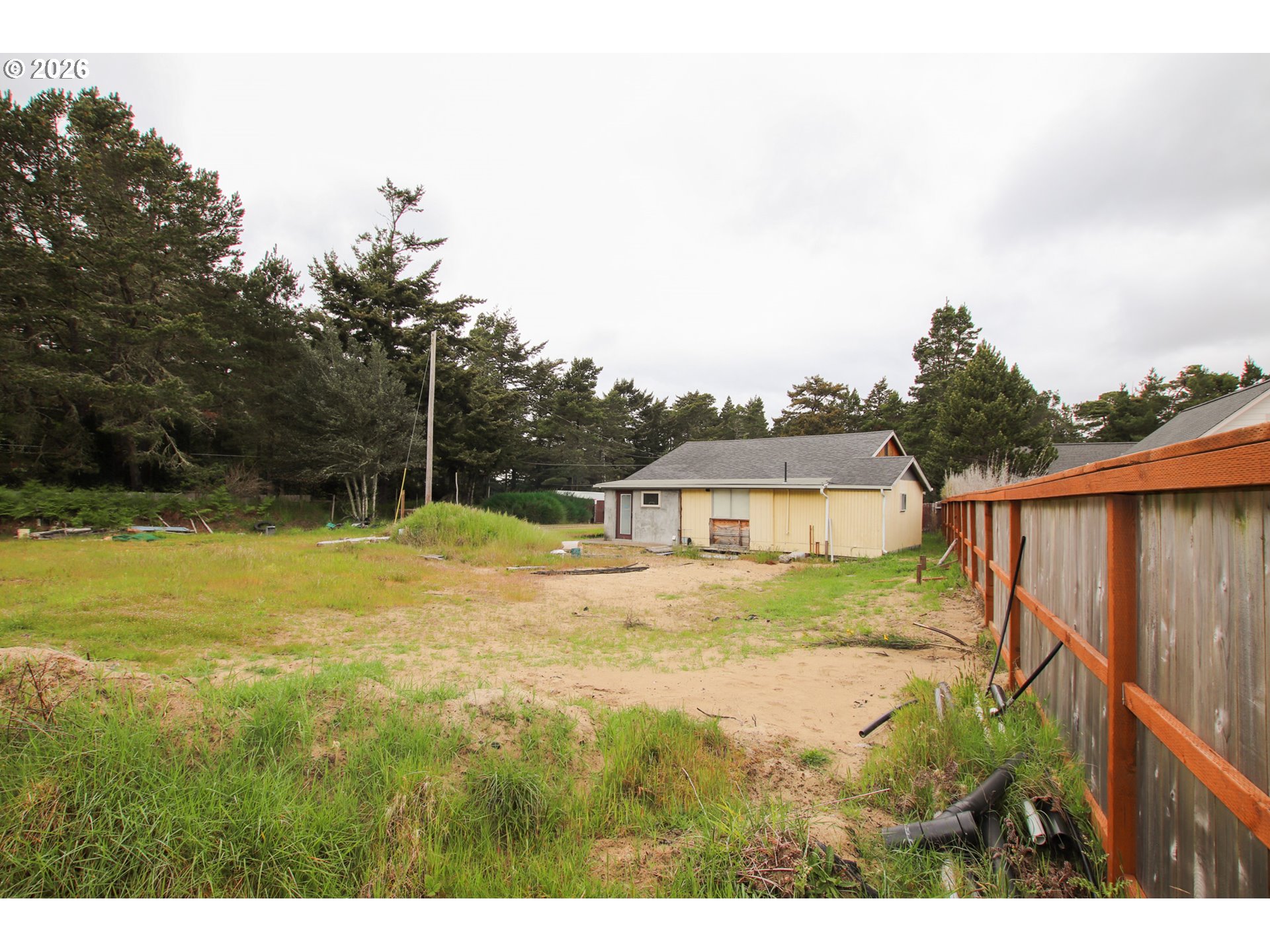 1120 Rhododendron Drive Florence, OR 97439 - Photo 6 of 6 a view of a house with a backyard