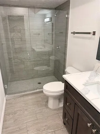 a bathroom with a sink a toilet and shower