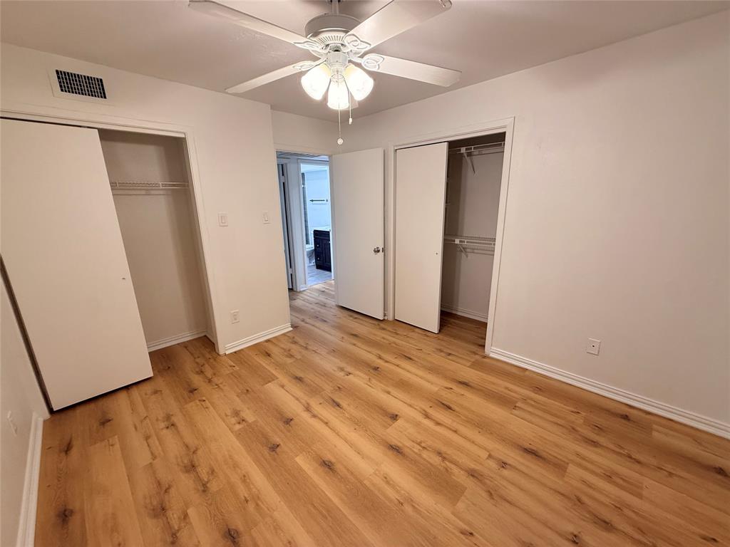 3933 Inwood Road, Unit 2023 Dallas, TX 75209 - Photo 16 of 24 a view of an empty room with wooden floor and a ceiling fan