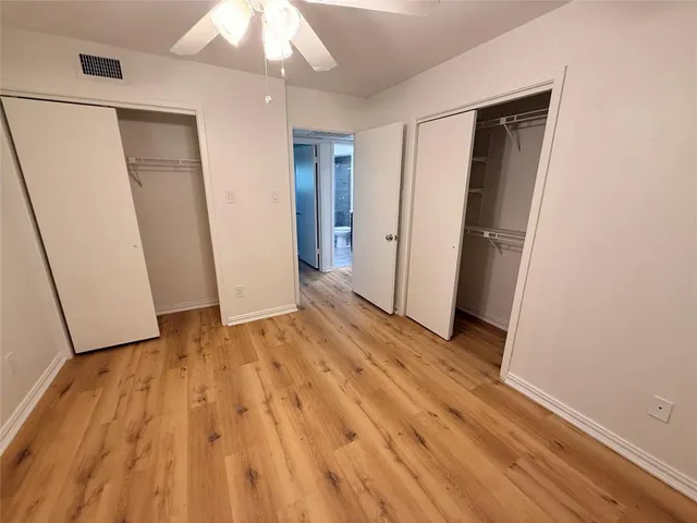 an empty room with wooden floor and closet