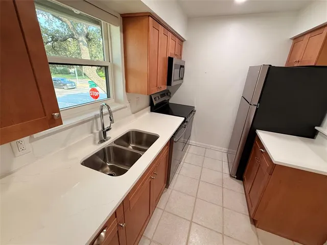 a kitchen with a sink a refrigerator and a window
