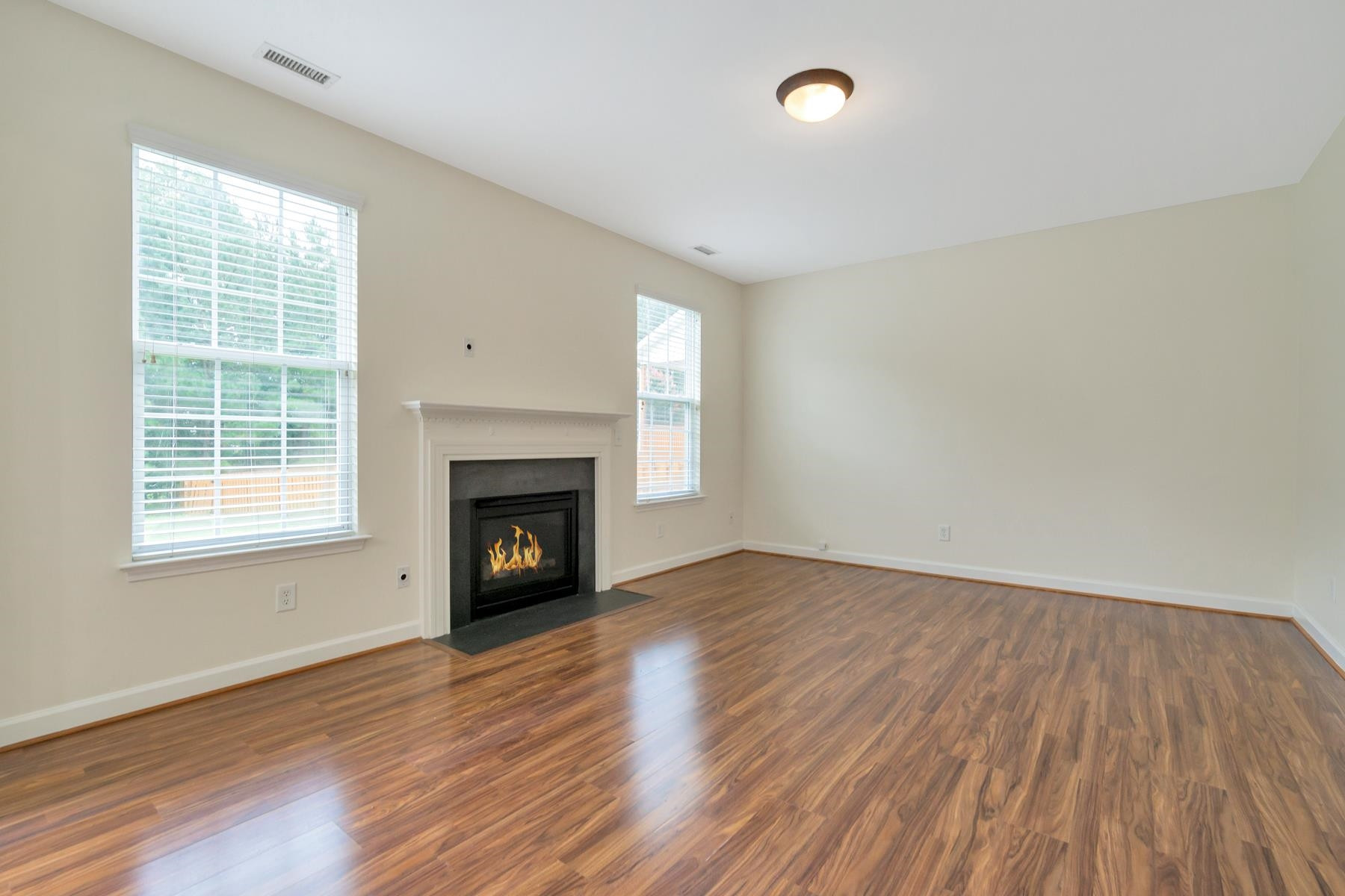 6316 Sparkling Brook Drive Raleigh, NC 27616 - Photo 16 of 44 an empty room with windows and a fireplace