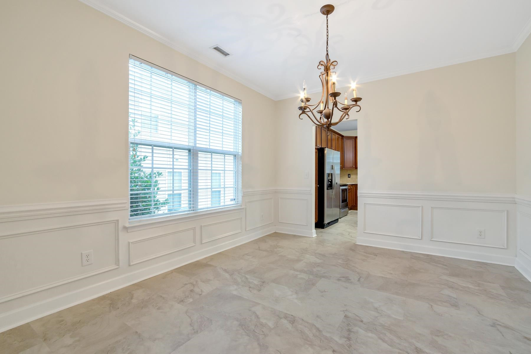 6316 Sparkling Brook Drive Raleigh, NC 27616 - Photo 21 of 44 an empty room with chandelier and windows