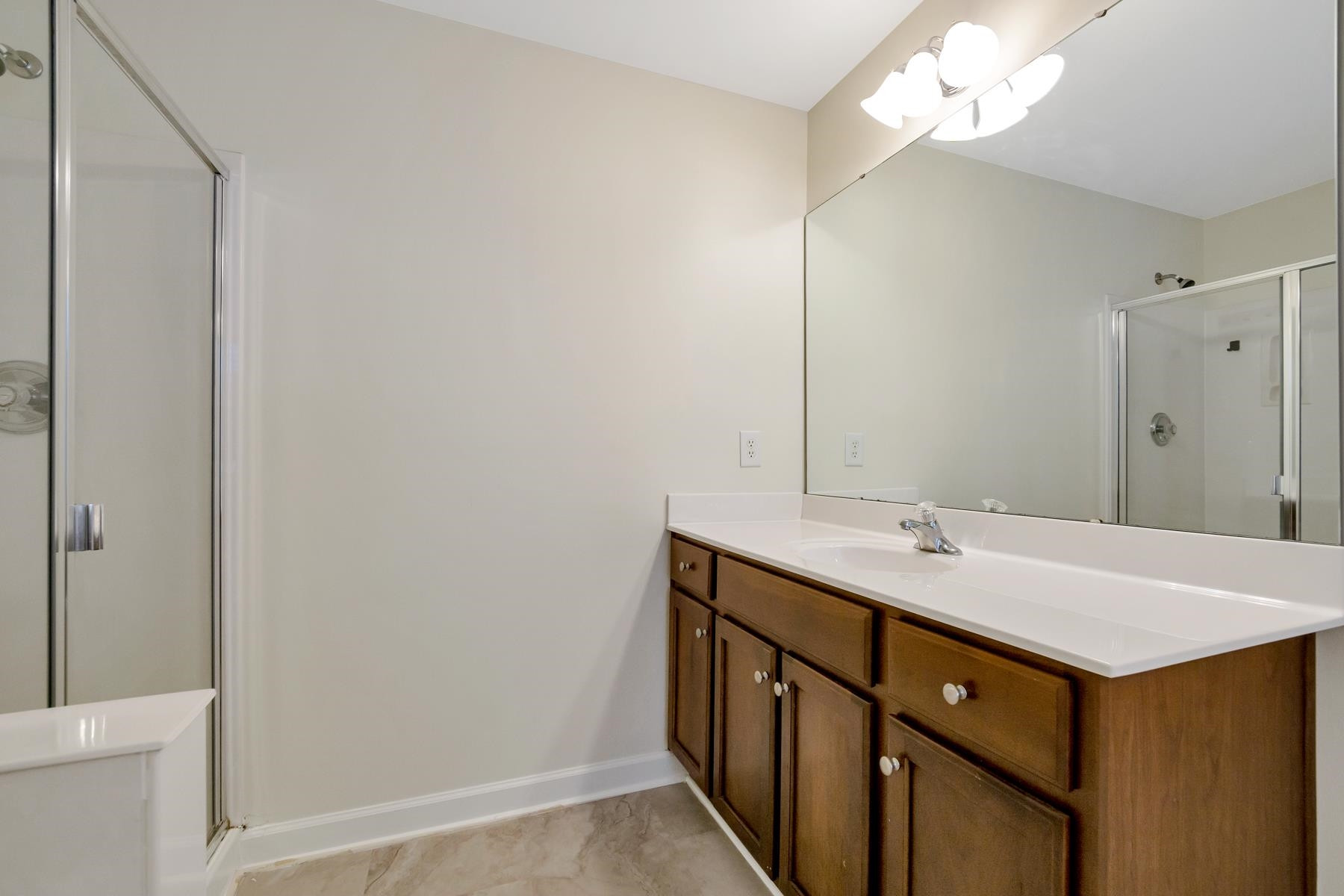 6316 Sparkling Brook Drive Raleigh, NC 27616 - Photo 36 of 44 a bathroom with a sink a mirror and a shower