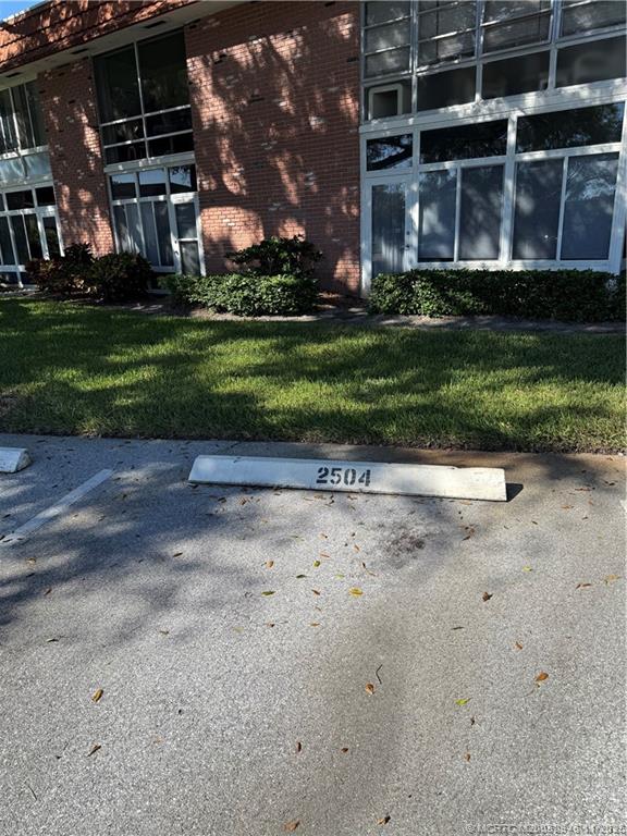 1225 Northwest 21st Street Northwest, Unit 2504 Stuart, FL 34994 - Photo 15 of 17 a front view of a house with a yard