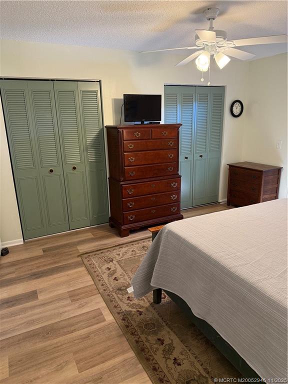 1225 Northwest 21st Street Northwest, Unit 2504 Stuart, FL 34994 - Photo 10 of 17 a bedroom with a bed and a chandelier