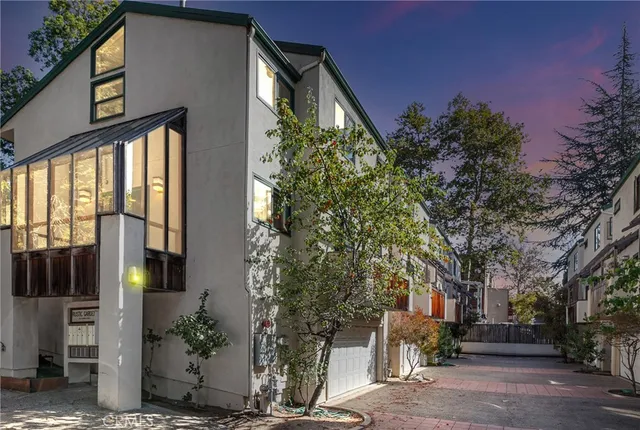 a front view of a house with a tree