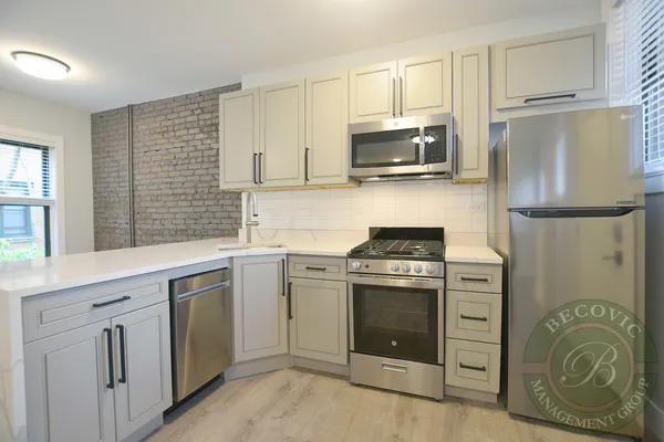 a kitchen with cabinets stainless steel appliances and a window