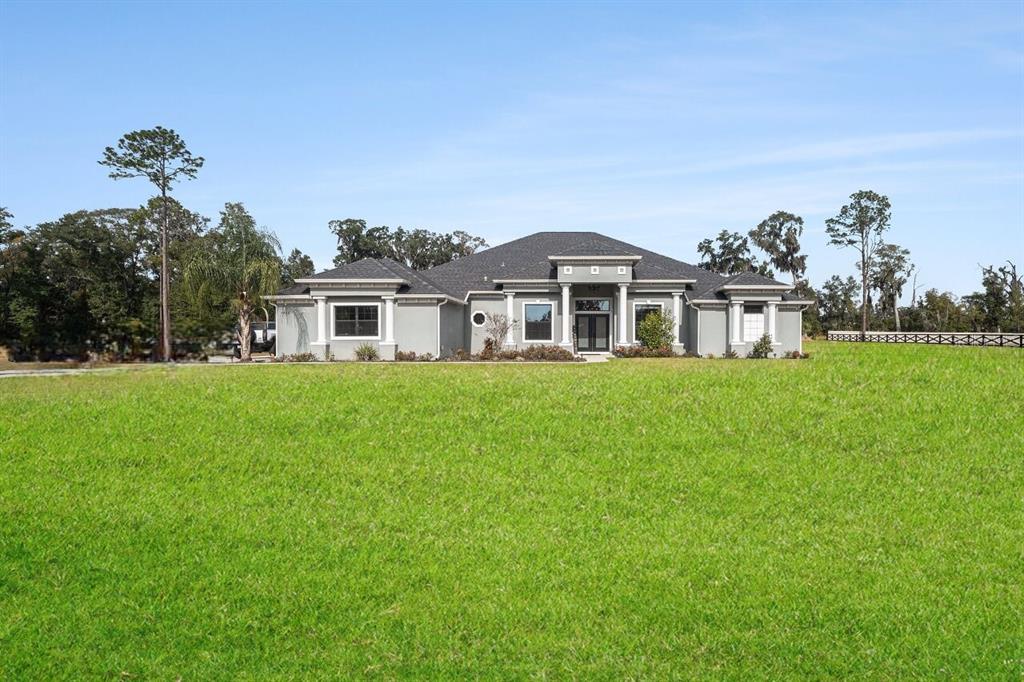 7403 Northeast 22nd Ct Road Ocala, FL 34479 - Photo 1 of 37 a front view of a house with garden