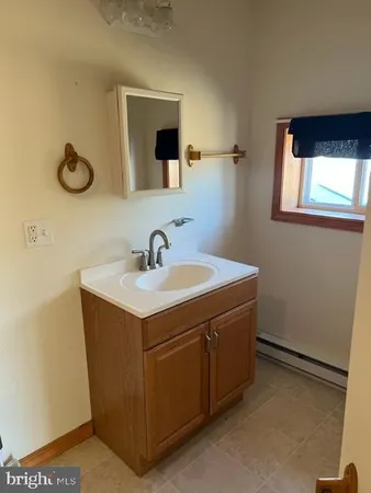 a utility room with a sink a vanity and mirror