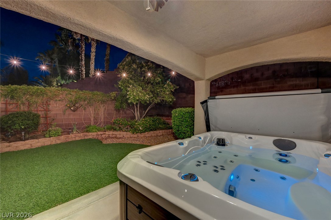 1604 Cattle Ranch Place Henderson, NV 89002 - Photo 6 of 99 Unwind in the bubbling spa under a canopy of string lights, overlooking a manicured yard.