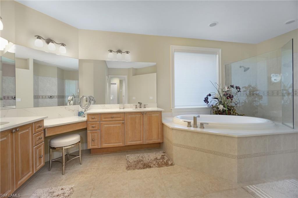 8007 Tiger Lily Drive Naples, FL 34113 - Photo 16 of 32 a spacious bathroom with a double vanity sink mirror and bathtub