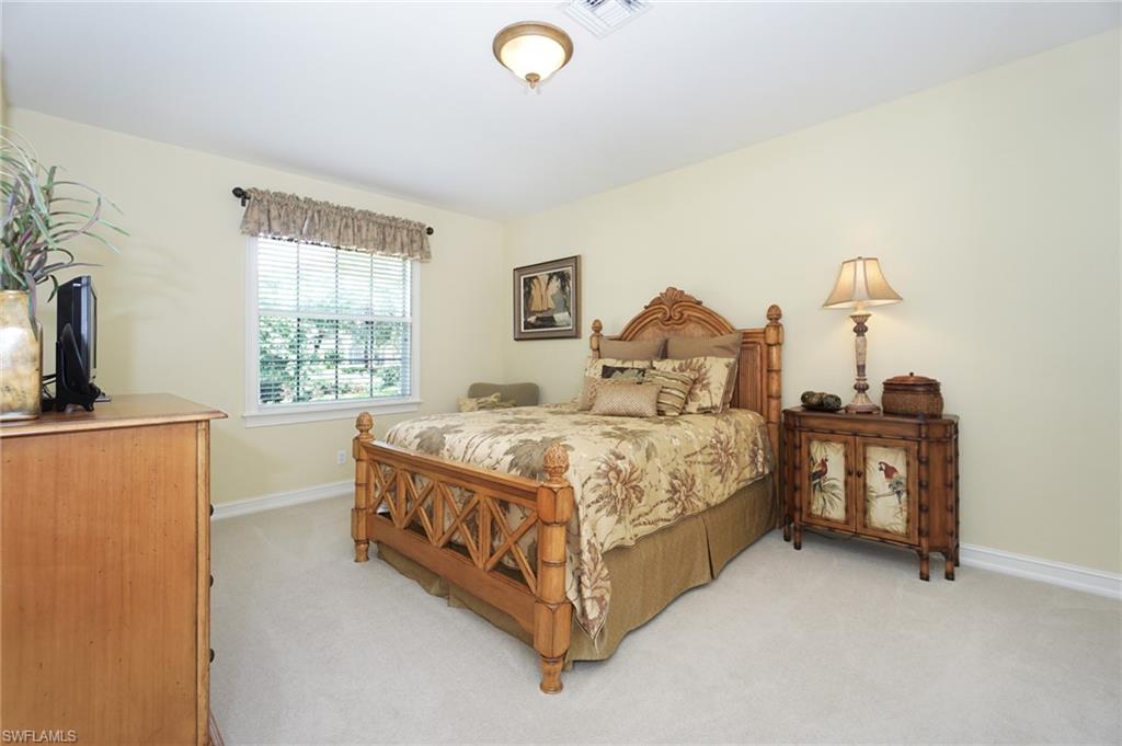 8007 Tiger Lily Drive Naples, FL 34113 - Photo 17 of 32 a spacious bedroom with a bed and a window