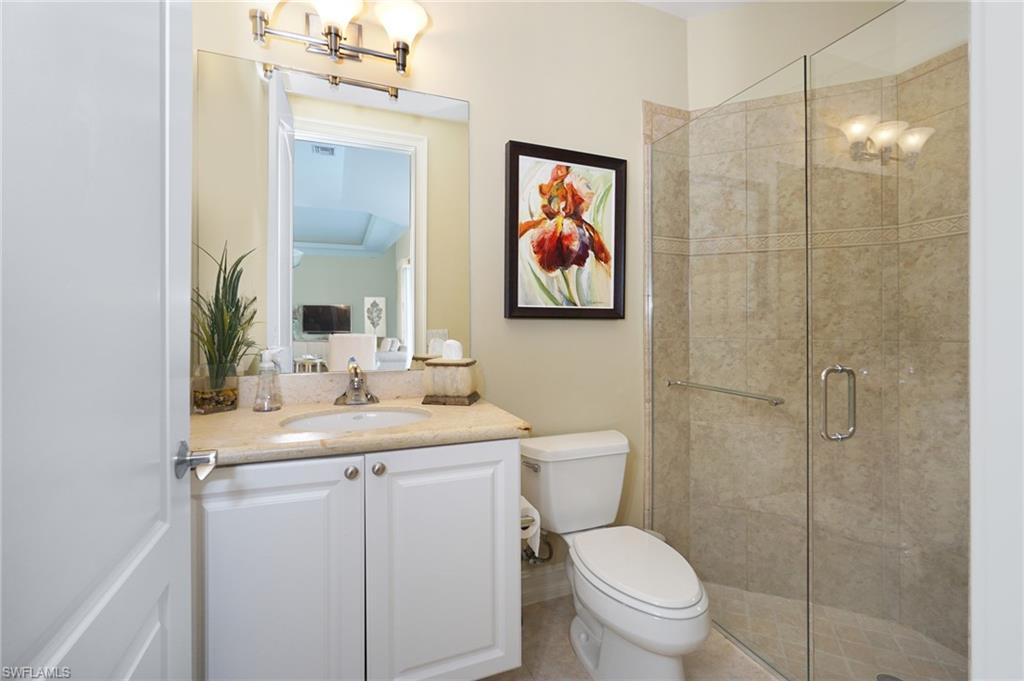 8007 Tiger Lily Drive Naples, FL 34113 - Photo 19 of 32 a bathroom with a toilet sink and mirror