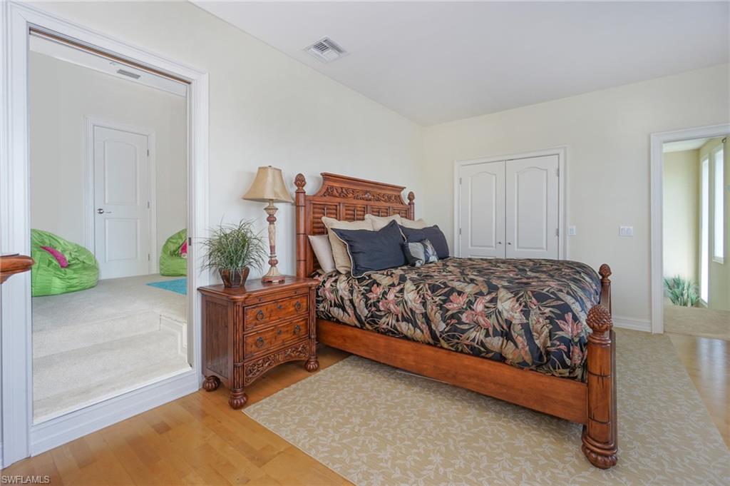 8007 Tiger Lily Drive Naples, FL 34113 - Photo 23 of 32 a bedroom with a bed and a potted plant