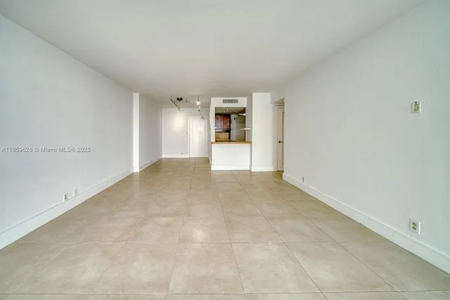 a view of a big room with wooden floor and a window