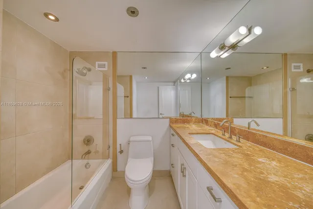 a spacious bathroom with a granite countertop sink mirror toilet and bathtub