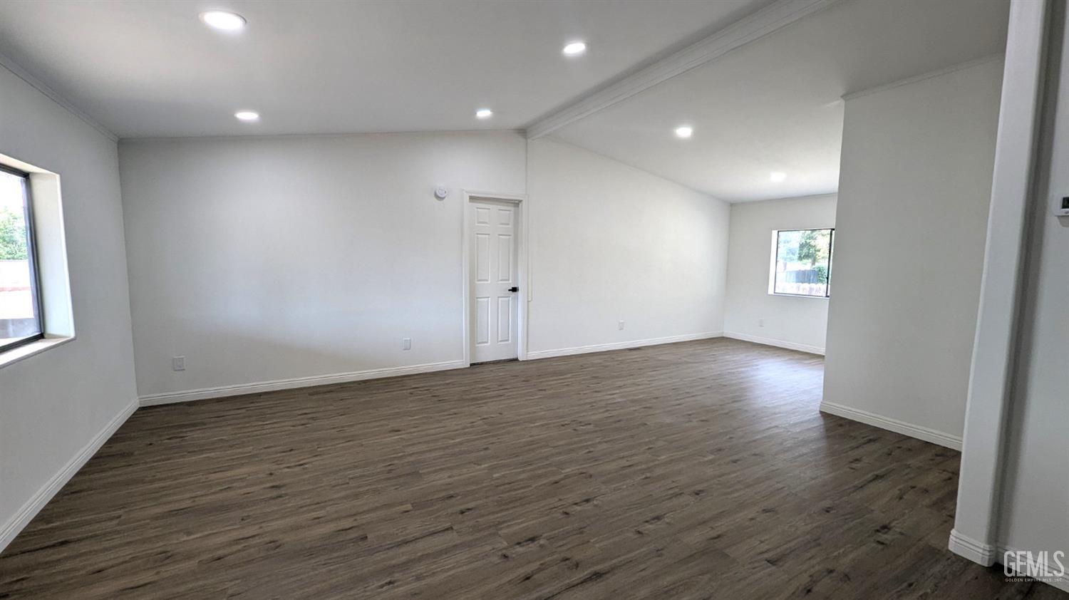 Undisclosed Address Wasco, CA 93280 - Photo 2 of 14 an empty room with wooden floor and windows