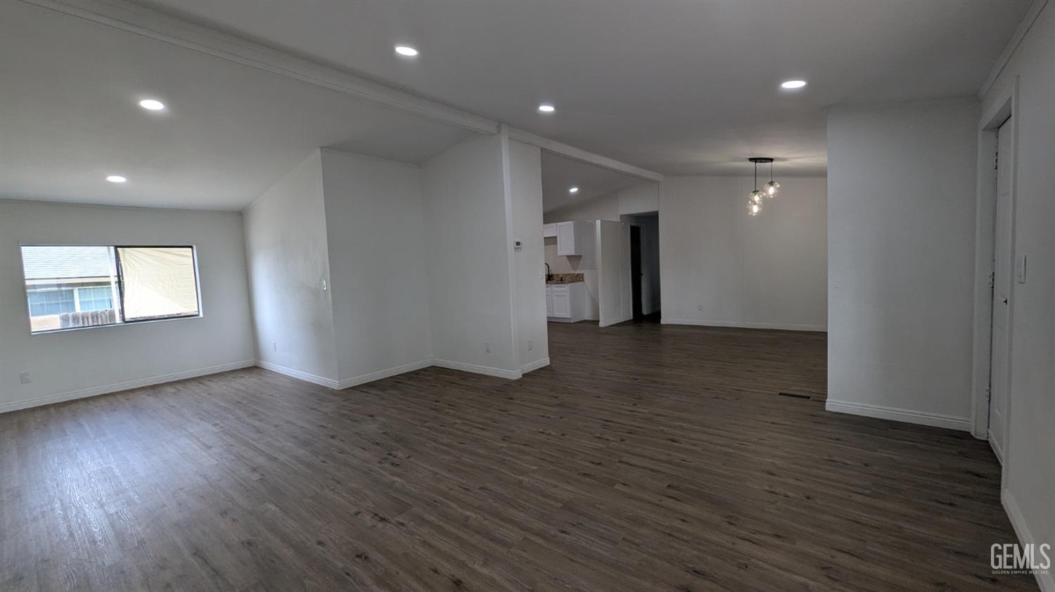 Undisclosed Address Wasco, CA 93280 - Photo 3 of 14 a view of an empty room with wooden floor and a window