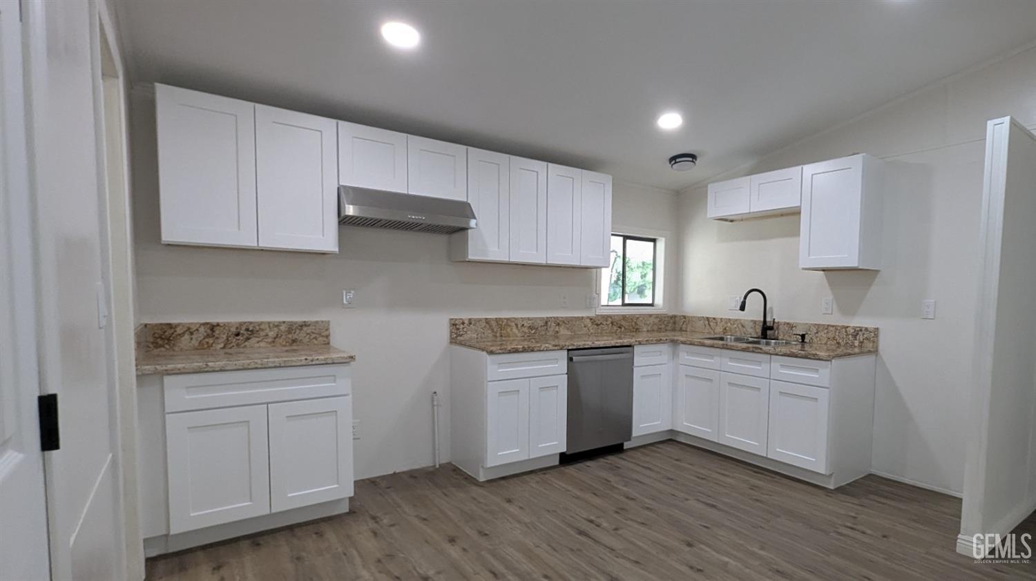 Undisclosed Address Wasco, CA 93280 - Photo 4 of 14 a kitchen with granite countertop white cabinets and a wooden floor
