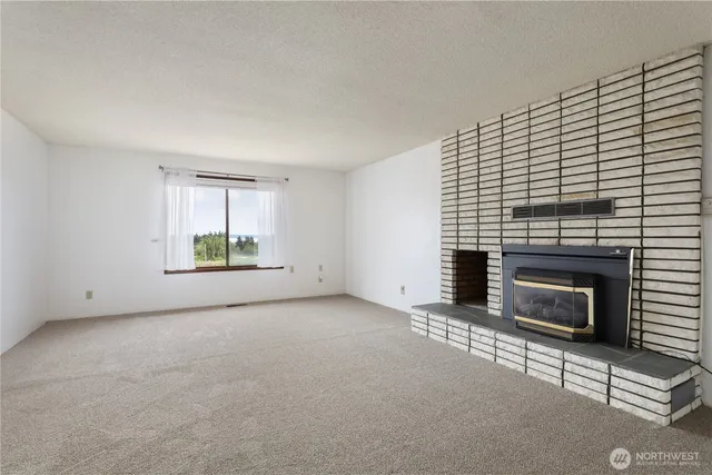 an empty room with windows and fireplace