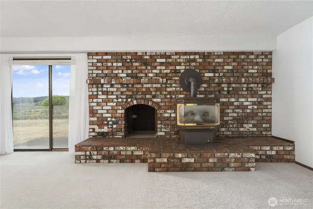 a living room with fireplace furniture and a floor to ceiling window