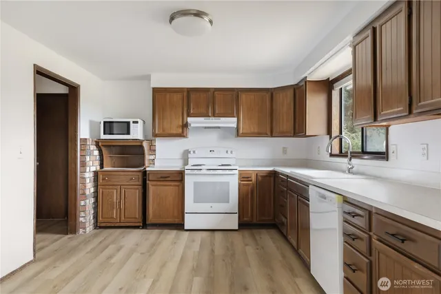 a kitchen with a sink cabinets stainless steel appliances and a window