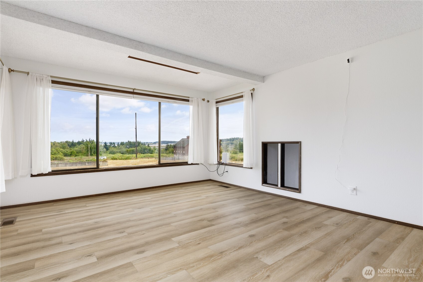 2725 Hunt Road Oak Harbor, WA 98277 - Photo 9 of 40 a view of an empty room with a window and wooden floor