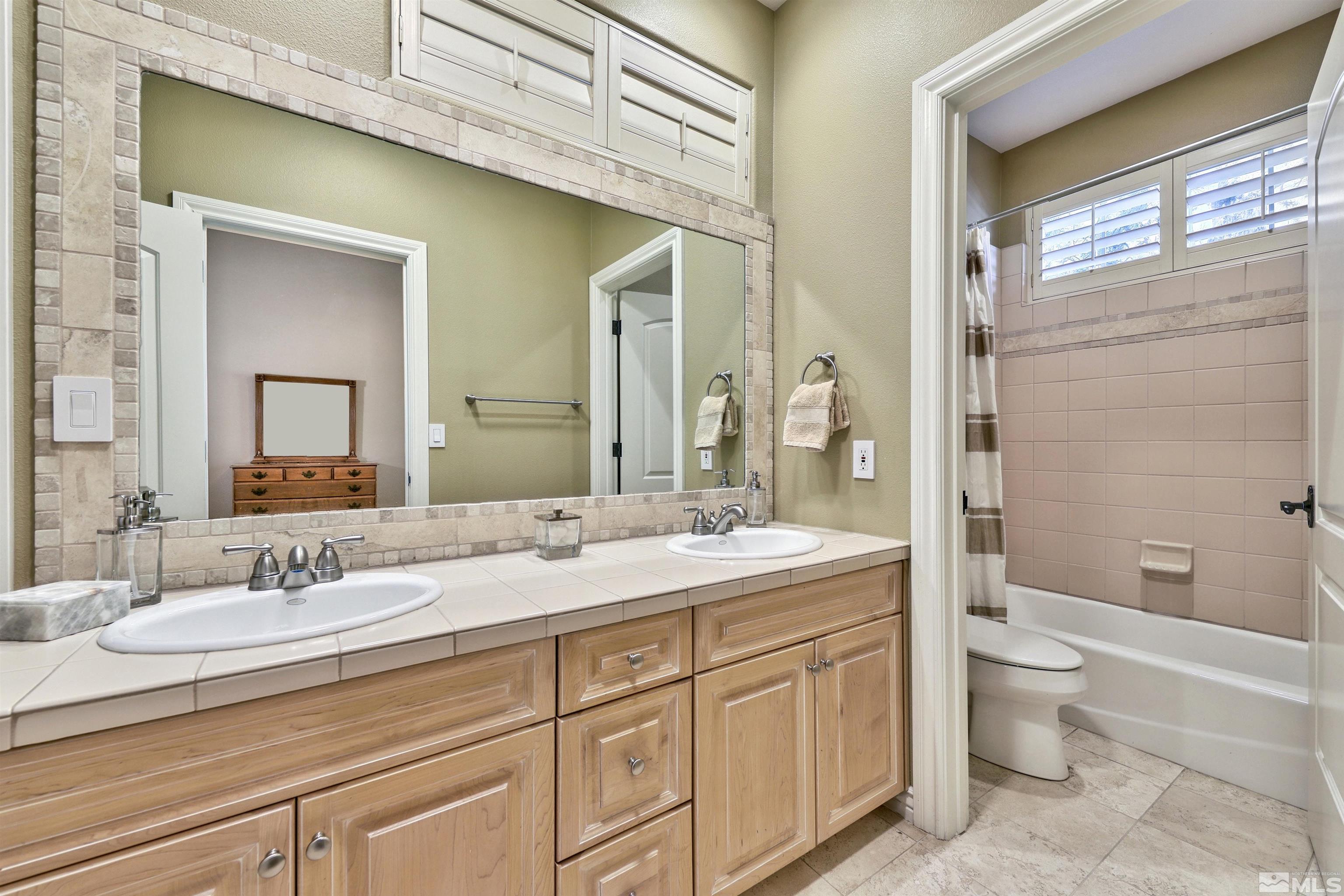 701 Aspen Trail Reno, NV 89519 - Photo 32 of 40 a bathroom with a double vanity sink toilet mirror and bathtub