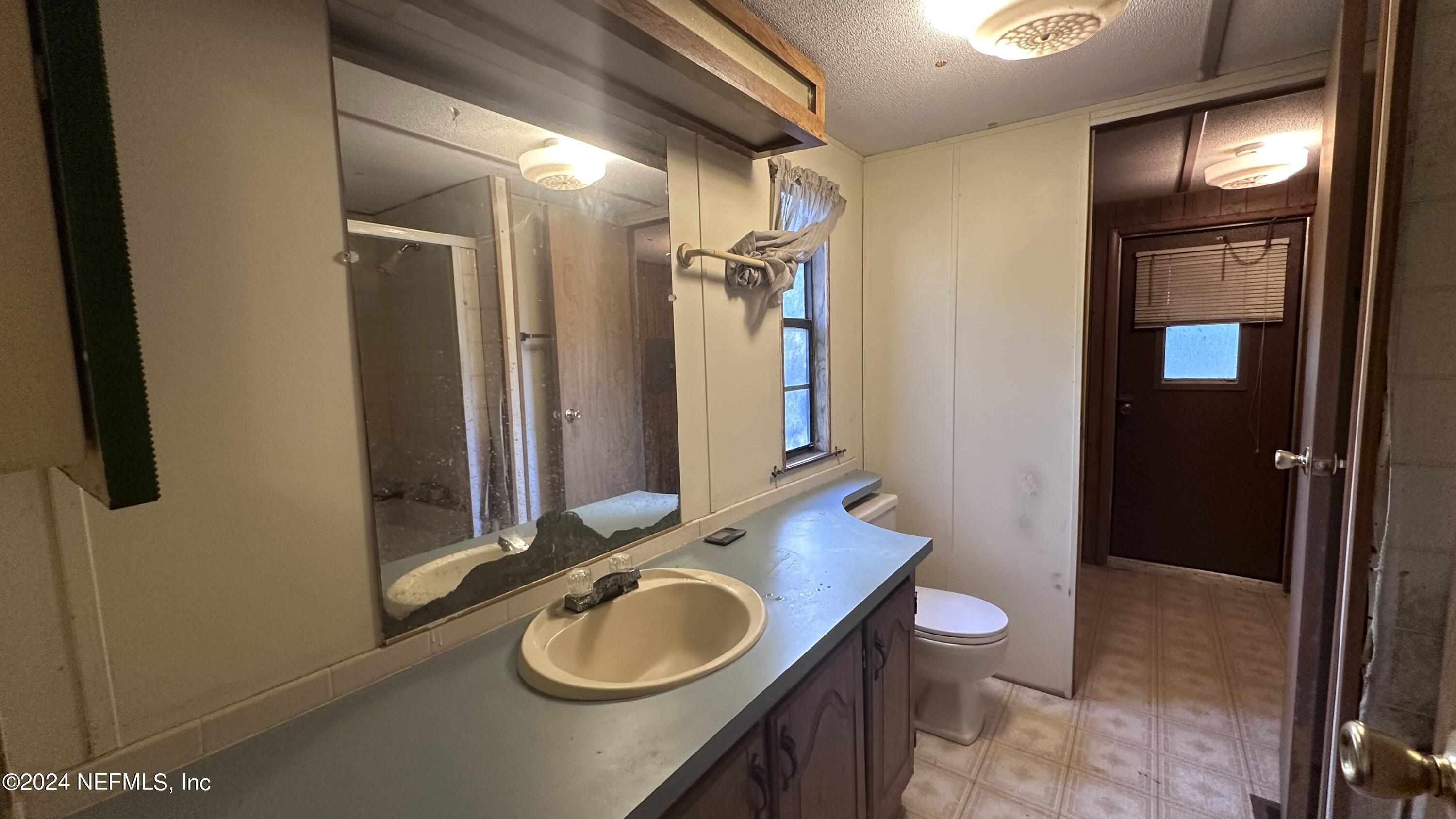5002 Herton Road Jacksonville, FL 32258 - Photo 16 of 21 a bathroom with a sink a toilet and a mirror