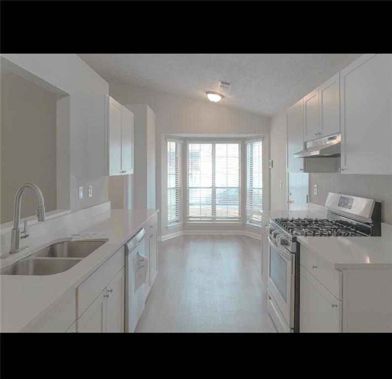 1350 Birdsong Lane Hampton, GA 30228 - Photo 2 of 9 a kitchen with a sink stove and cabinets